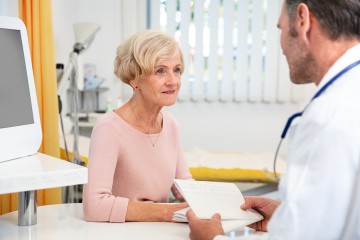 ein Arzt redet mit einer älteren Patientin
