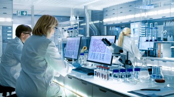 Forscherinnen in einem Labor sitzen vor Computern