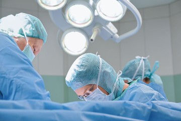 Das Bild zeigt Ärzte bei einer Operation.