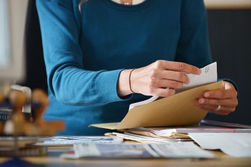 Eine Person steckt ein Dokument in eine Aktenmappe.