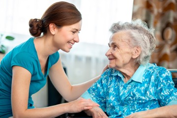 Junge Pflegerin im Gespräch mit einer Seniorin