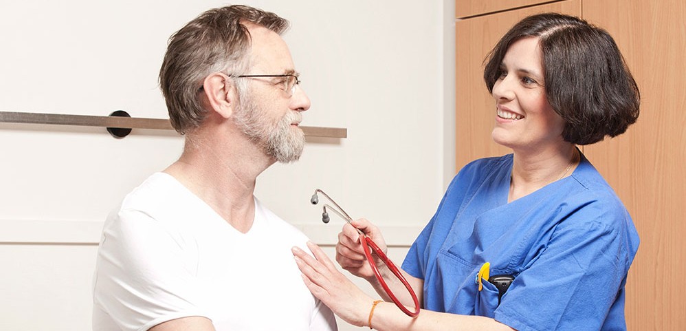 Das Bild zeigt eine Ärztin mit einem Patienten.