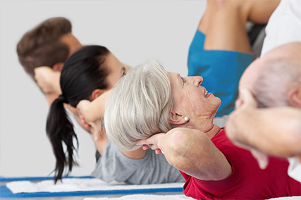 vier Personen in Großaufnahme, die Sit-ups trainieren